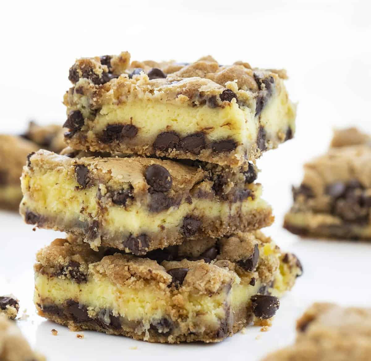 The amazing flavors of chocolate chip cookie and cheesecake join perfectly in these easy peasy Chocolate Chip Cheesecake Bars! Chocolate Chip Bars, Bars Recipe, Chocolate Bars, Chocolate Chip Cheesecake Bars Recipe, How to Make Bars with Cheesecake, Stuffed Chocolate Chip Bars, Baking, Chocolate Chip, Recipes, i am baker, iambaker Chocolate Chip Cheesecake Bars Stacked Three High and Showing Cream Cheese Inside