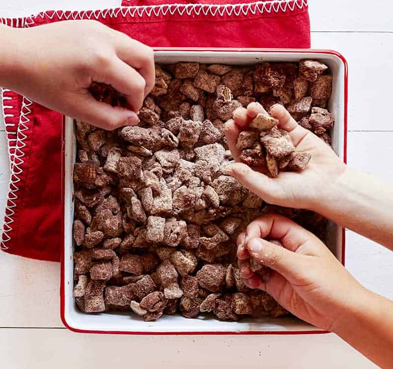 Add this Brownie Puppy Chow recipe to get that brownie fix without turning on the oven brownie puppy chow, puppy chow, chex cereal, rice chex, brownie mix, muddie buddies, brownie muddy buddies Grabbing a handful of Brownie Puppy Chow