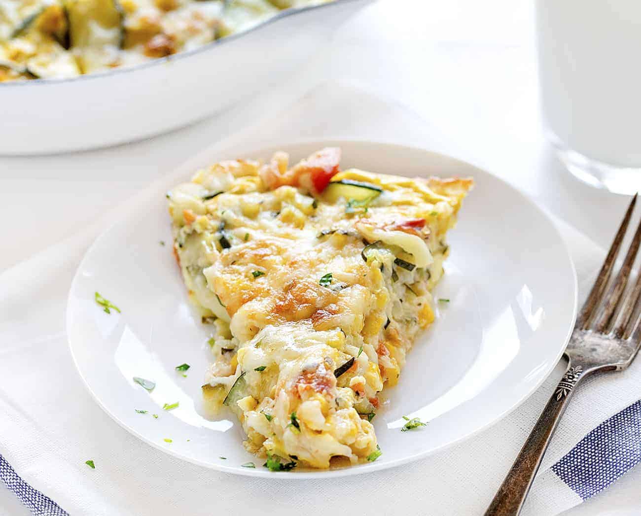 Zucchini and Sweet Corn Quiche will be your fuel for the day or a satisfying dinner! zucchini and sweet corn quiche, zucchini recipes, zucchini, iambaker, quiche, crustless quiche, egg bake One Piece of Zucchini and Corn Quiche on a Plate