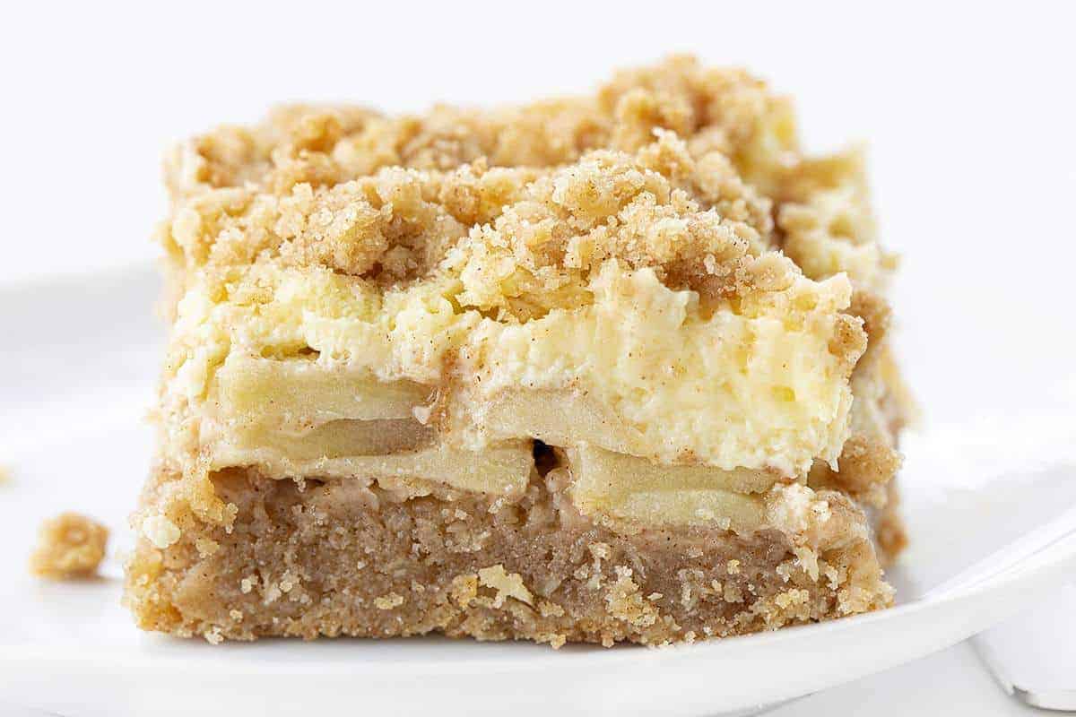 One Apple Cream Cheese Bar on White Plate Very Close Showing the Apples and Cream Cheese Layers
