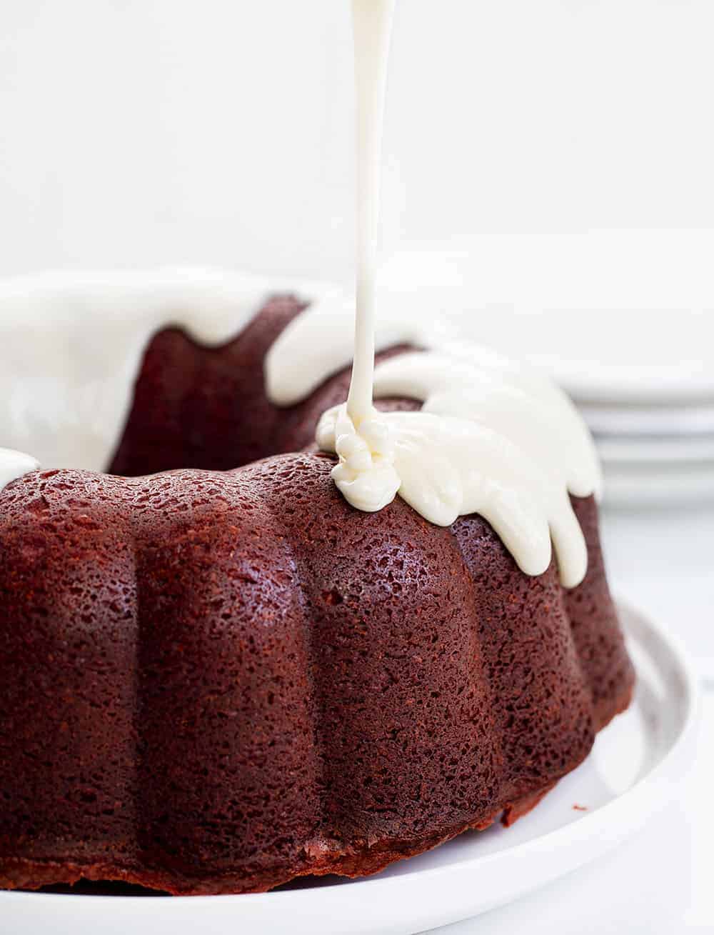 Red Velvet Pound Cake is a delicate, yet dense, cake that has a slight, but not too sweet chocolate flavor with a cream cheese frosting as the icing on the cake, literally! Red Velvet Cake, Red Velvet Pound Cake, Cream Cheese Frosting, Moist Red Velvet Cake, Bundt Cake, Pound Cake, Red Velvet, Baking, Recipes, Dessert, Red Velvet, i am baker, iambaker Pouring Glaze over Red Velvet Pound Cake