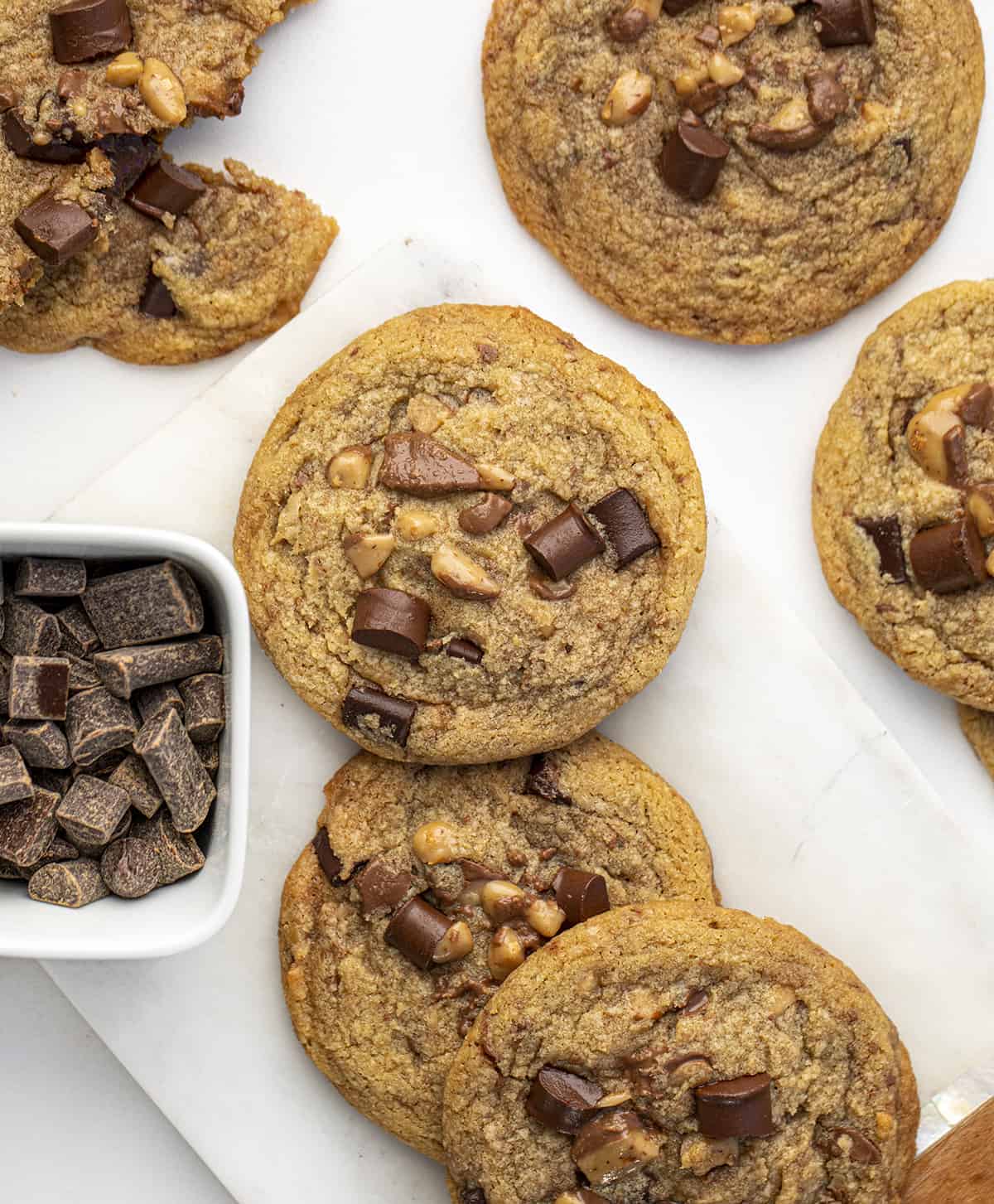 Browned Butter Toffee Cookies with Chocolate Chunks are crispy and chewy cookies made with browned butter, toffee bits, and chocolate chunks. Cookies, Baking, Cookie Recipes, Cookie Exchange, Holiday Baking, Brown Butter, Toffee Cookies, Chocolate, i am baker, iambaker, recipes Brown Butter Toffee Cookies with Chocolate Chunks on a Counter with Chocolate Chunks next to it