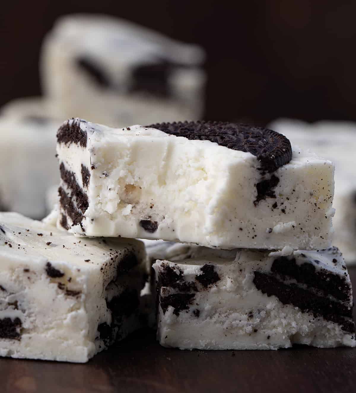 Cookies and Cream Fudge is an easy-to-make treat with white chocolate chips, marshmallow fluff, and Oreo cookies. It should definitely be added to your list of holiday treats this season! Bit into Piece of Cookies and Cream Fudge Stacked up.