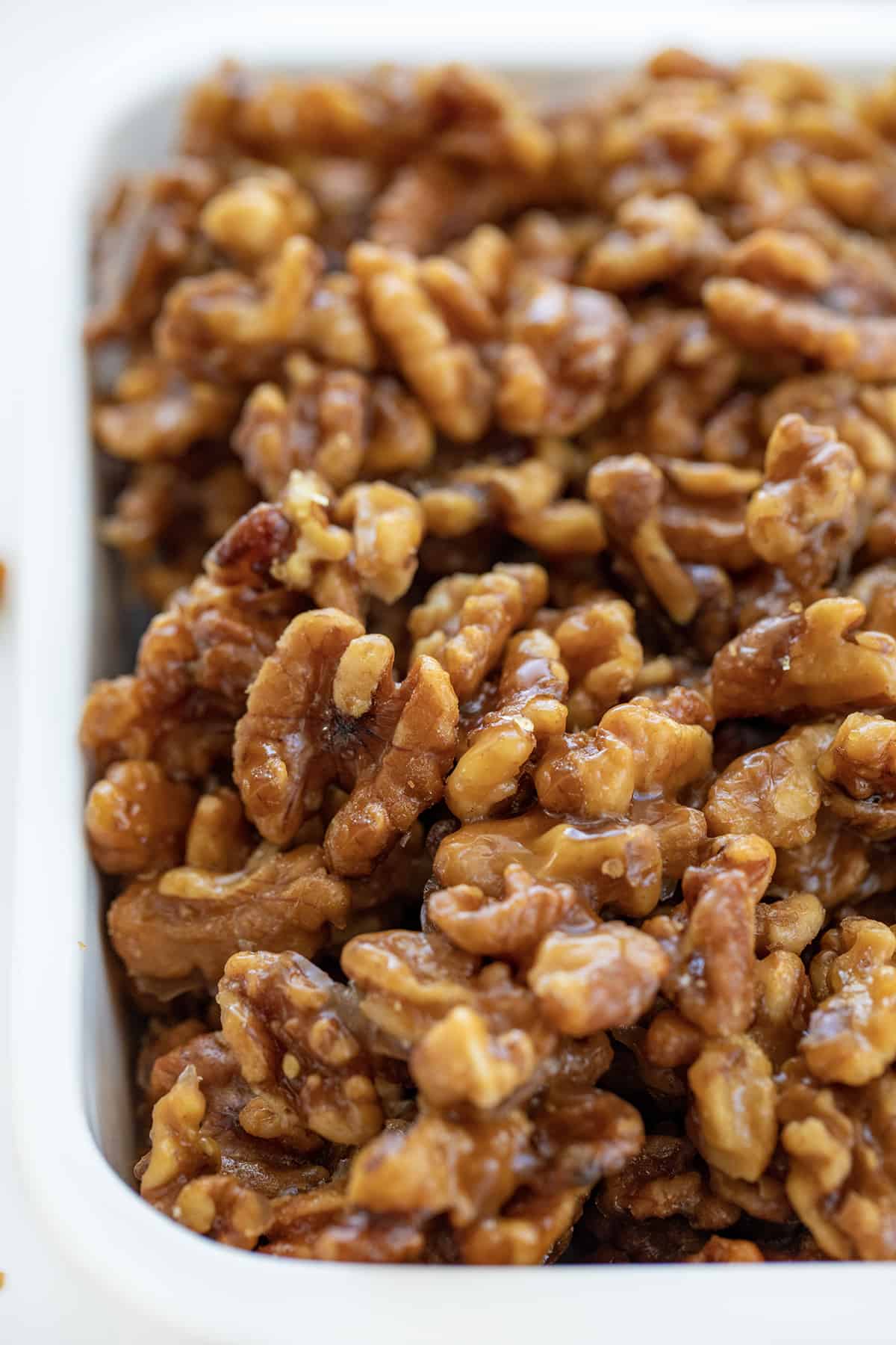 This is the ONLY candied walnut recipe you will ever need!! Candied Walnuts are walnuts that have been coated with a buttery sweet mixture and then baked to a crunchy golden brown. They are an addicting snack on their own, but also a delicious topping for salads and desserts. And, they can even be made in an air fryer! Candied Walnuts in a Pan Close Up.