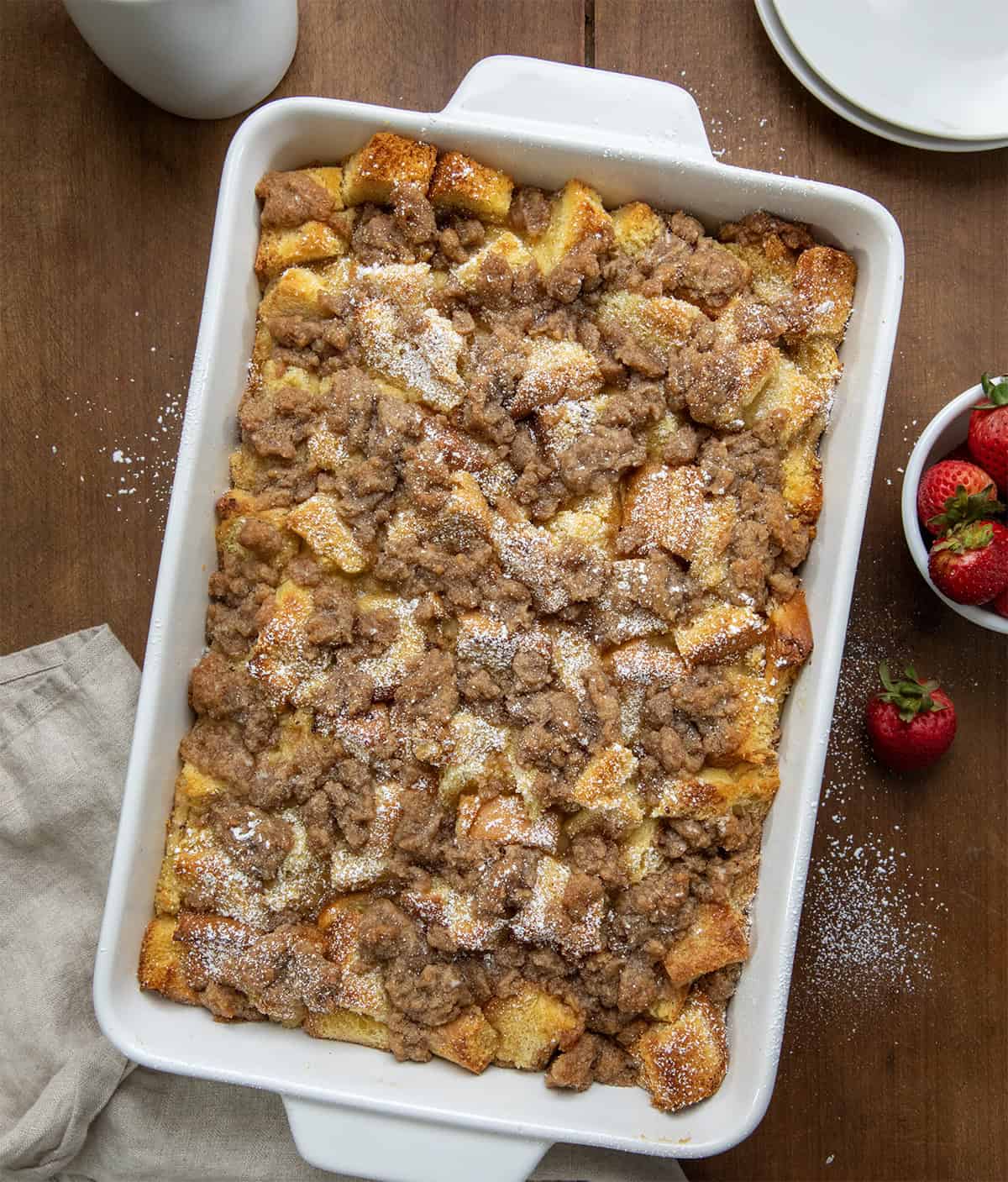 This Overnight French Toast Casserole is perfect for prepping ahead so it's easy to throw in the oven for a special breakfast, brunch, or just a delicious way to start your day! Overnight French Toast Casserole on a wooden table fro overhead.