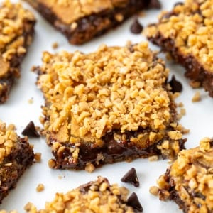 Chocolate Chip Toffee Fudge Bars on a white table spread out.